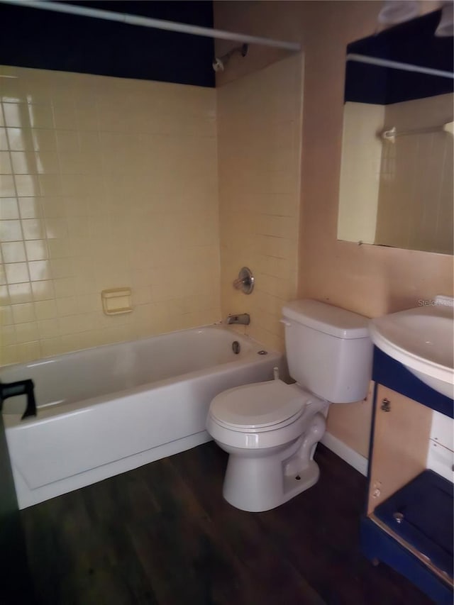 full bathroom featuring sink, wood-type flooring, toilet, and tiled shower / bath