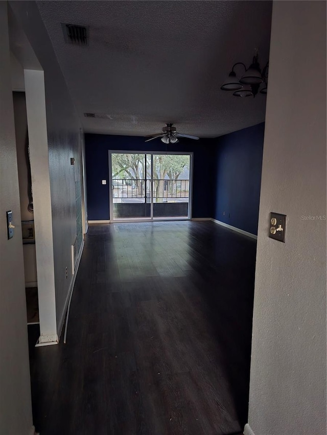 spare room featuring ceiling fan, dark hardwood / wood-style floors, and a textured ceiling