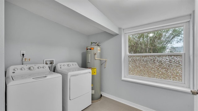 clothes washing area featuring light tile patterned floors, washer and clothes dryer, and electric water heater