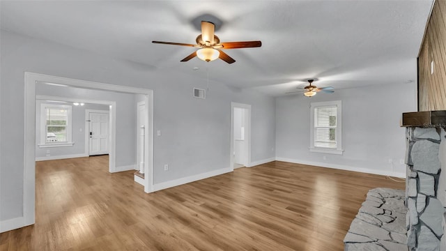 unfurnished living room featuring ceiling fan and light wood-type flooring