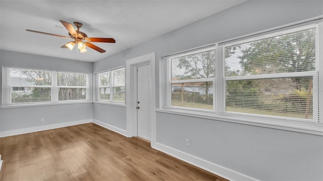 unfurnished sunroom with ceiling fan