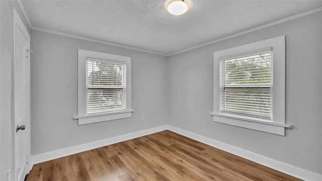 unfurnished room with hardwood / wood-style flooring, crown molding, a healthy amount of sunlight, and a textured ceiling