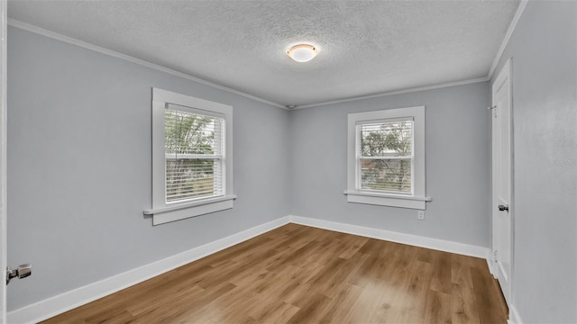 spare room with crown molding, light hardwood / wood-style flooring, and a textured ceiling