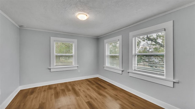 spare room with hardwood / wood-style flooring, ornamental molding, and a wealth of natural light