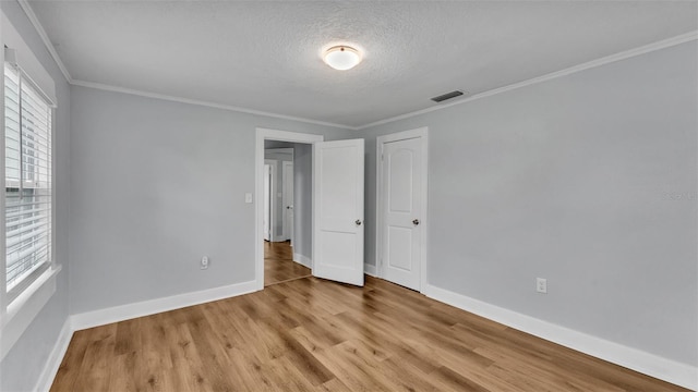 interior space with crown molding, a textured ceiling, and light hardwood / wood-style floors