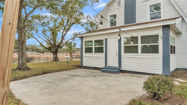 exterior space featuring a front lawn and a patio area