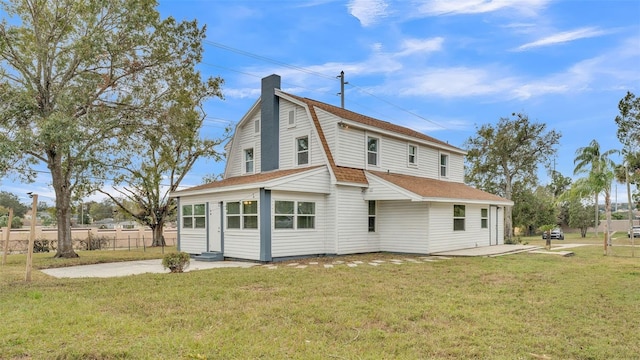 rear view of property with a yard and a patio area