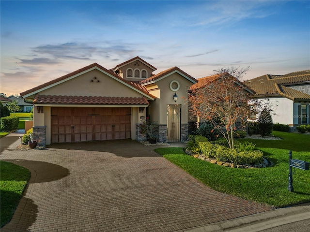 mediterranean / spanish home with a garage and a lawn