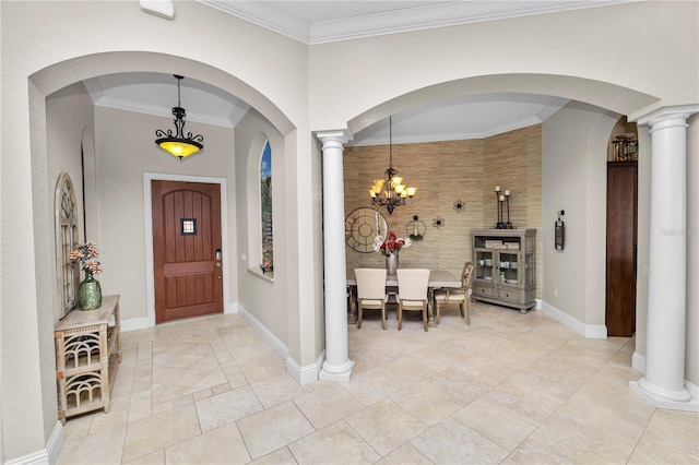 entrance foyer with ornamental molding, decorative columns, and a notable chandelier