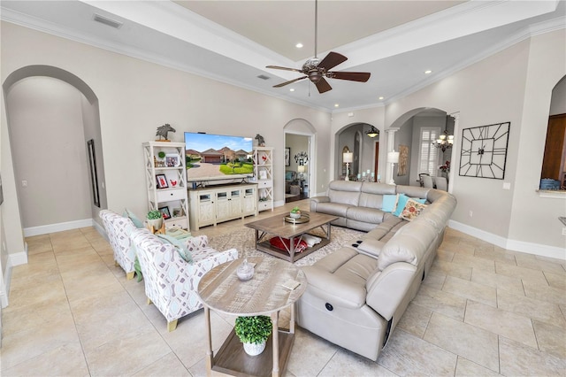 living room with light tile patterned floors, ornamental molding, a raised ceiling, and ceiling fan