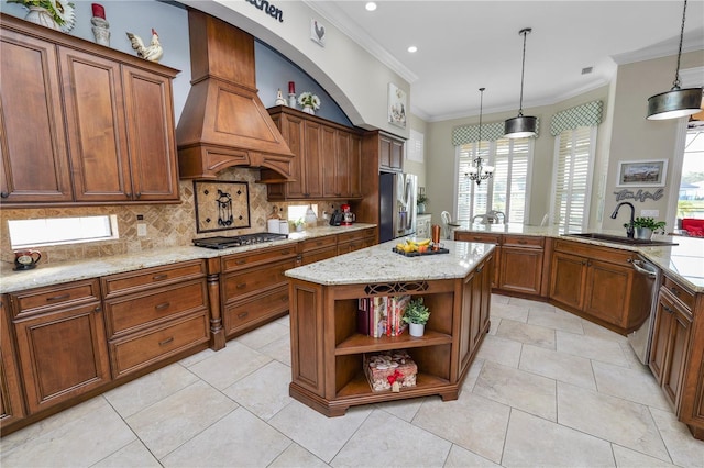 kitchen with sink, custom exhaust hood, decorative light fixtures, appliances with stainless steel finishes, and a kitchen island