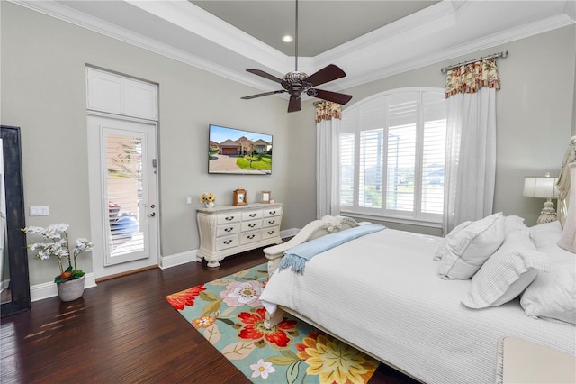 bedroom with dark wood-type flooring, a tray ceiling, multiple windows, and access to outside