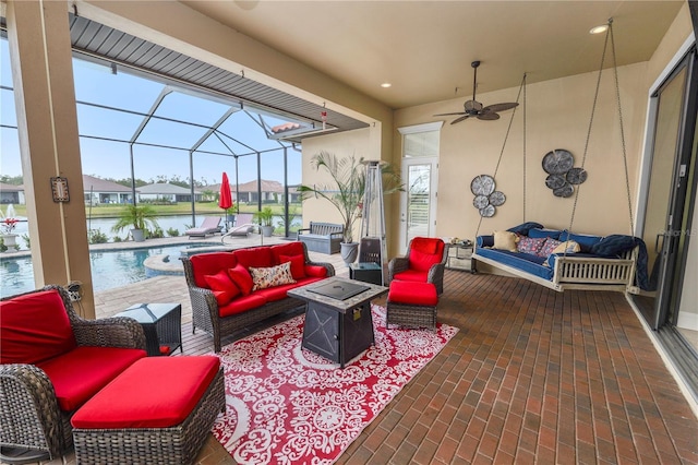 view of patio / terrace featuring a water view, ceiling fan, an outdoor hangout area, and a lanai