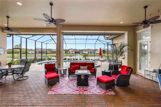 view of patio / terrace featuring a water view, ceiling fan, a lanai, and an outdoor hangout area