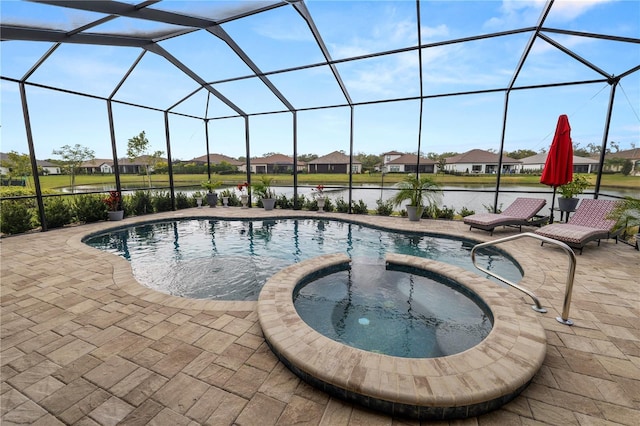 view of pool with an in ground hot tub, a patio, a water view, and glass enclosure