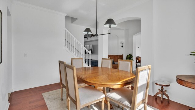 dining space with ornamental molding and dark hardwood / wood-style floors