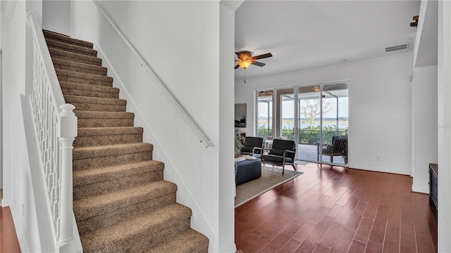 stairway featuring ceiling fan and wood-type flooring