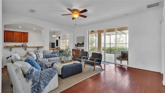 living room featuring ornamental molding, ceiling fan, and dark hardwood / wood-style flooring