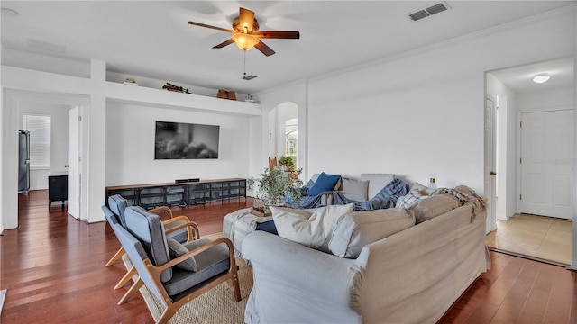 living room featuring wood-type flooring, ornamental molding, and ceiling fan