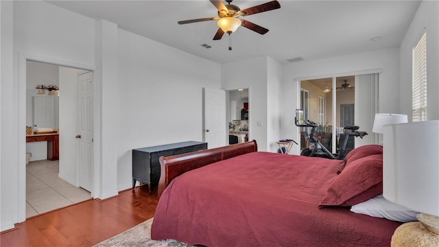 bedroom with ceiling fan, ensuite bath, and light hardwood / wood-style flooring