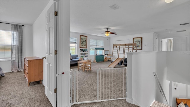 carpeted living room with ceiling fan