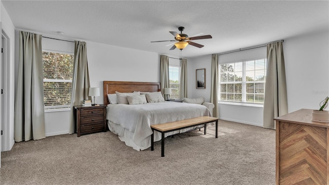 bedroom with a textured ceiling, light colored carpet, and ceiling fan