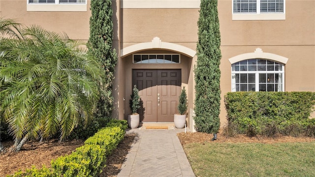 doorway to property with a lawn