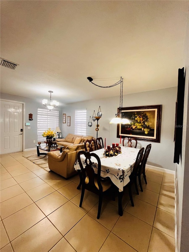 dining room with an inviting chandelier and light tile patterned floors