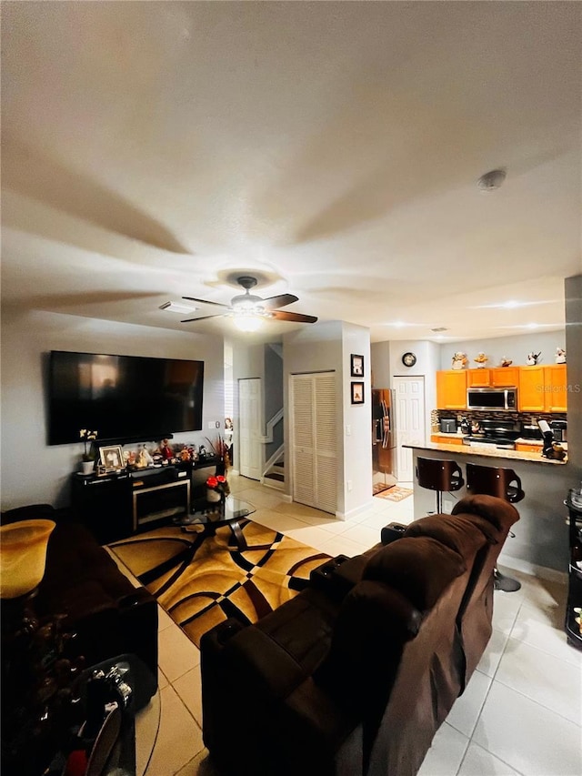 living room with light tile patterned floors and ceiling fan