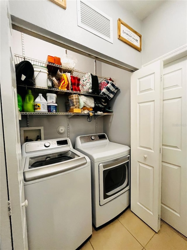 clothes washing area with light tile patterned floors and independent washer and dryer