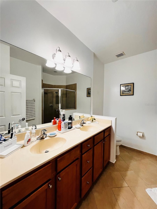 bathroom featuring vanity, tile patterned flooring, a shower with door, and toilet