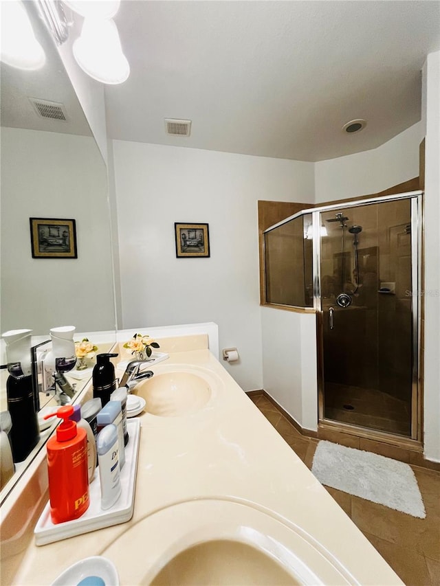 bathroom featuring tile patterned flooring, vanity, and a shower with door