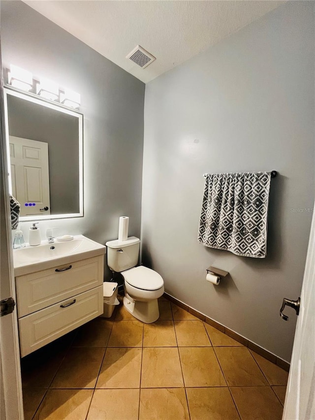 bathroom with vanity, tile patterned floors, a textured ceiling, and toilet