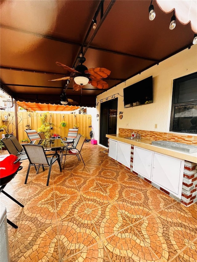 view of patio featuring ceiling fan and sink