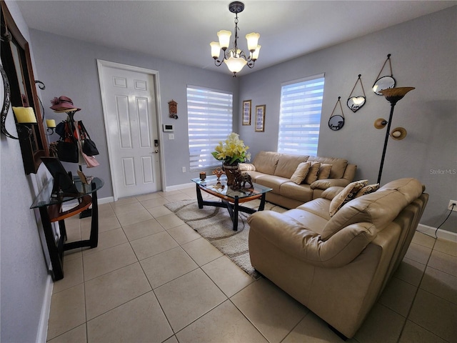 living area featuring light tile patterned flooring, a notable chandelier, and baseboards