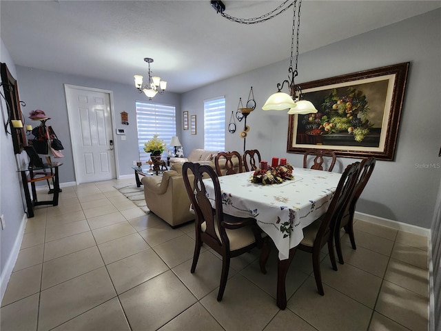 dining room with light tile patterned floors, a chandelier, and baseboards