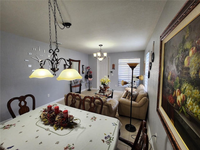 tiled dining space featuring baseboards and a chandelier