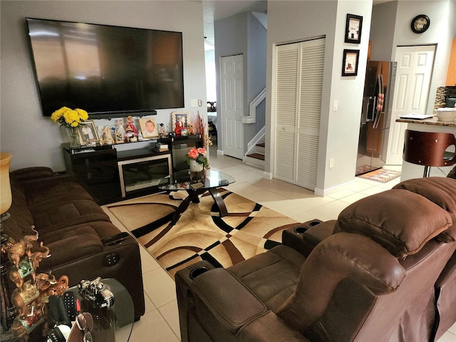 living room featuring baseboards, stairway, and light tile patterned flooring