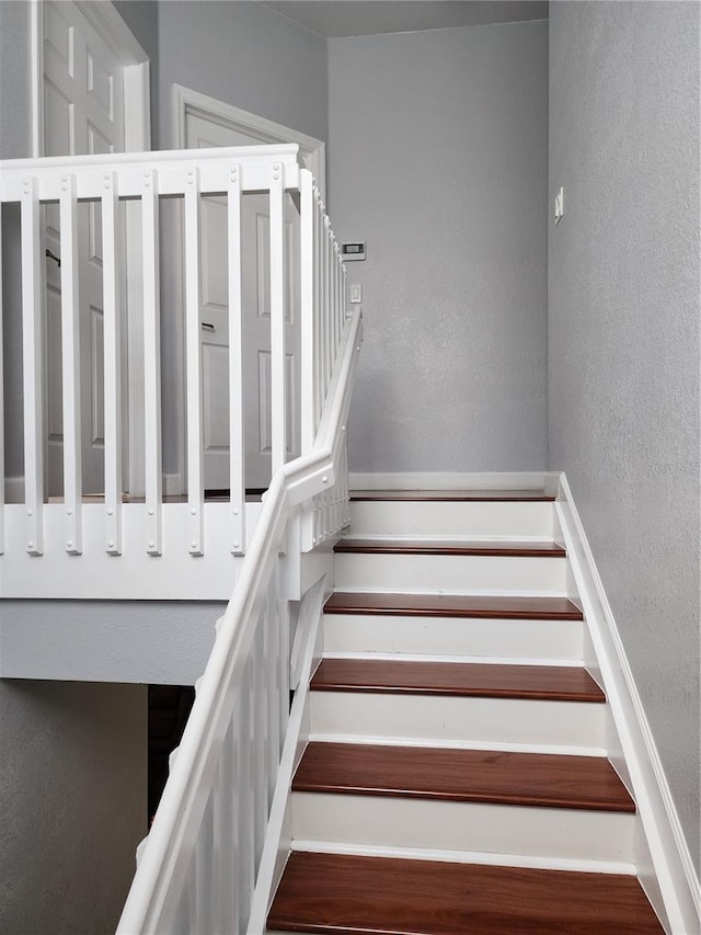 stairway featuring a textured wall