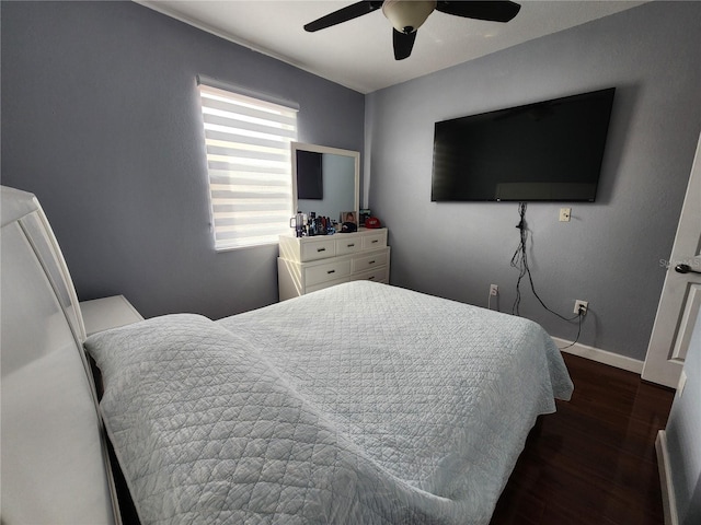 bedroom with ceiling fan, baseboards, and dark wood-style flooring