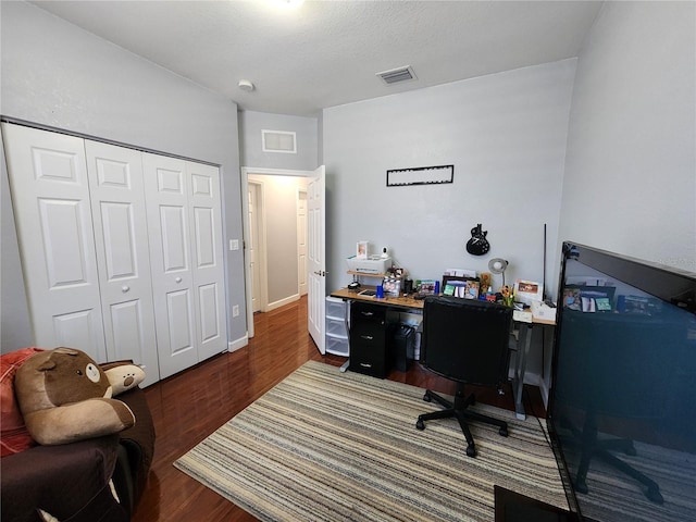 office area featuring dark wood finished floors, visible vents, and baseboards