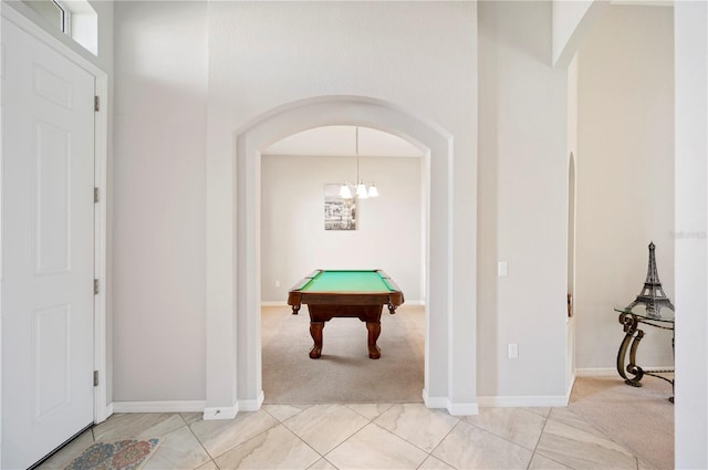 rec room featuring arched walkways, pool table, light colored carpet, and baseboards