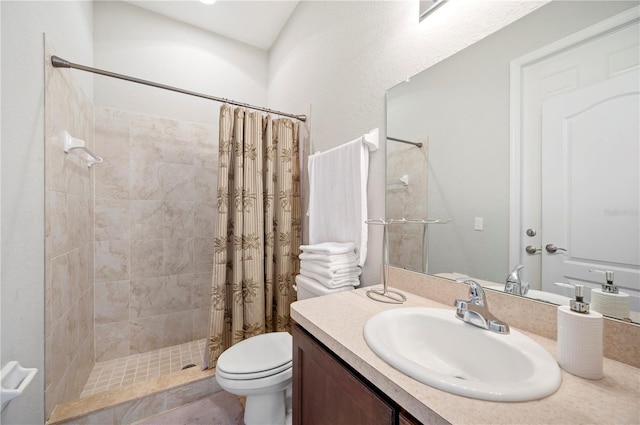 full bath with tiled shower, vanity, and toilet