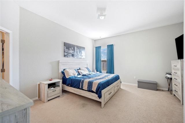 bedroom with baseboards and light colored carpet