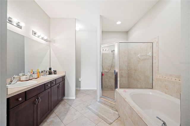 bathroom featuring a bath, a shower stall, double vanity, and a sink