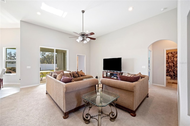 living room with arched walkways, a high ceiling, recessed lighting, and light colored carpet