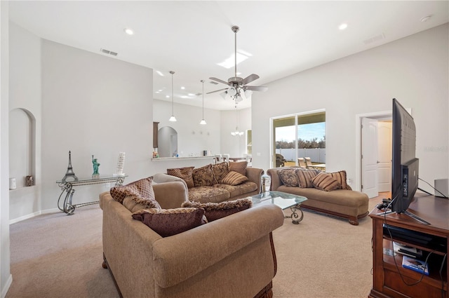 living area featuring arched walkways, recessed lighting, visible vents, a ceiling fan, and carpet