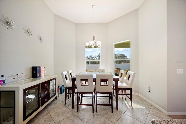 dining area featuring an inviting chandelier, light tile patterned floors, and baseboards