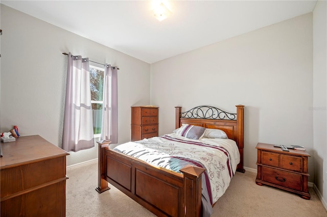 bedroom featuring light carpet and baseboards