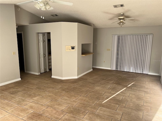 empty room with lofted ceiling, a textured ceiling, and ceiling fan